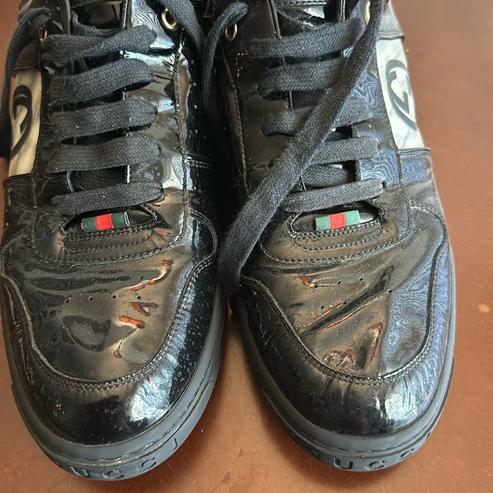 Men’s black Gucci, tennis shoes with Gucci symbol on the side slightly worn